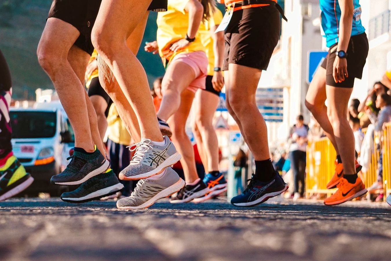 Close view of marathon runners legs and racing shoes striking asphalt