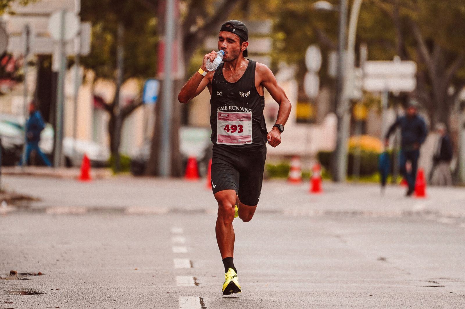 Marathon runner drinking from a bottle while running